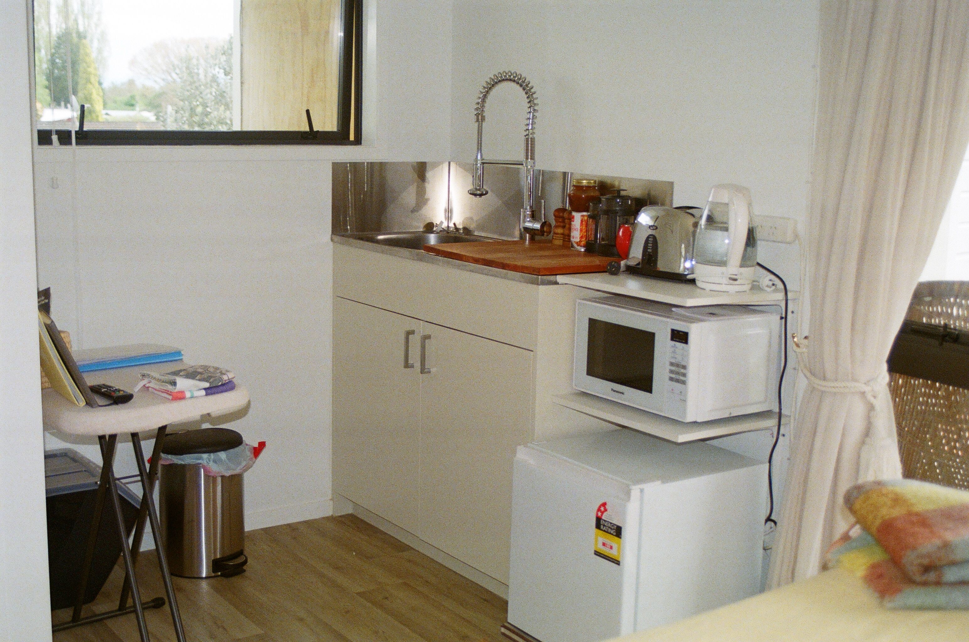 A compact kitchenette with a sink, a microwave, and a small refrigerator.