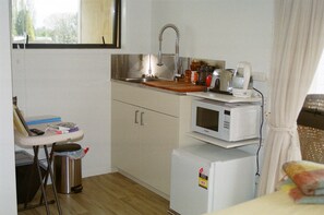 A compact kitchenette with a sink, a microwave, and a small refrigerator.