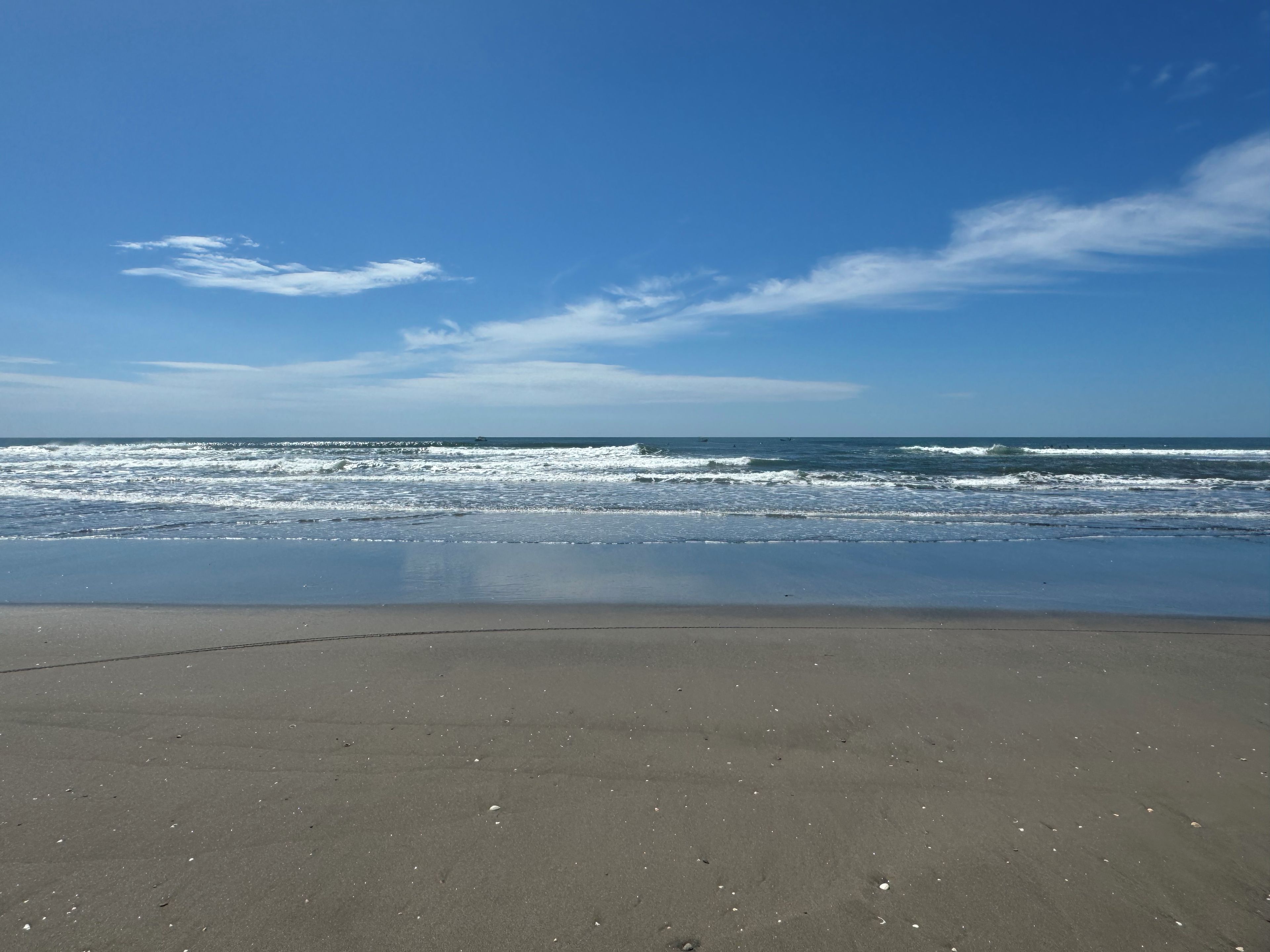 A beach with a clear sky and calm sea.