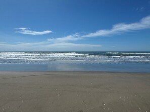 A beach with a clear sky and calm sea.