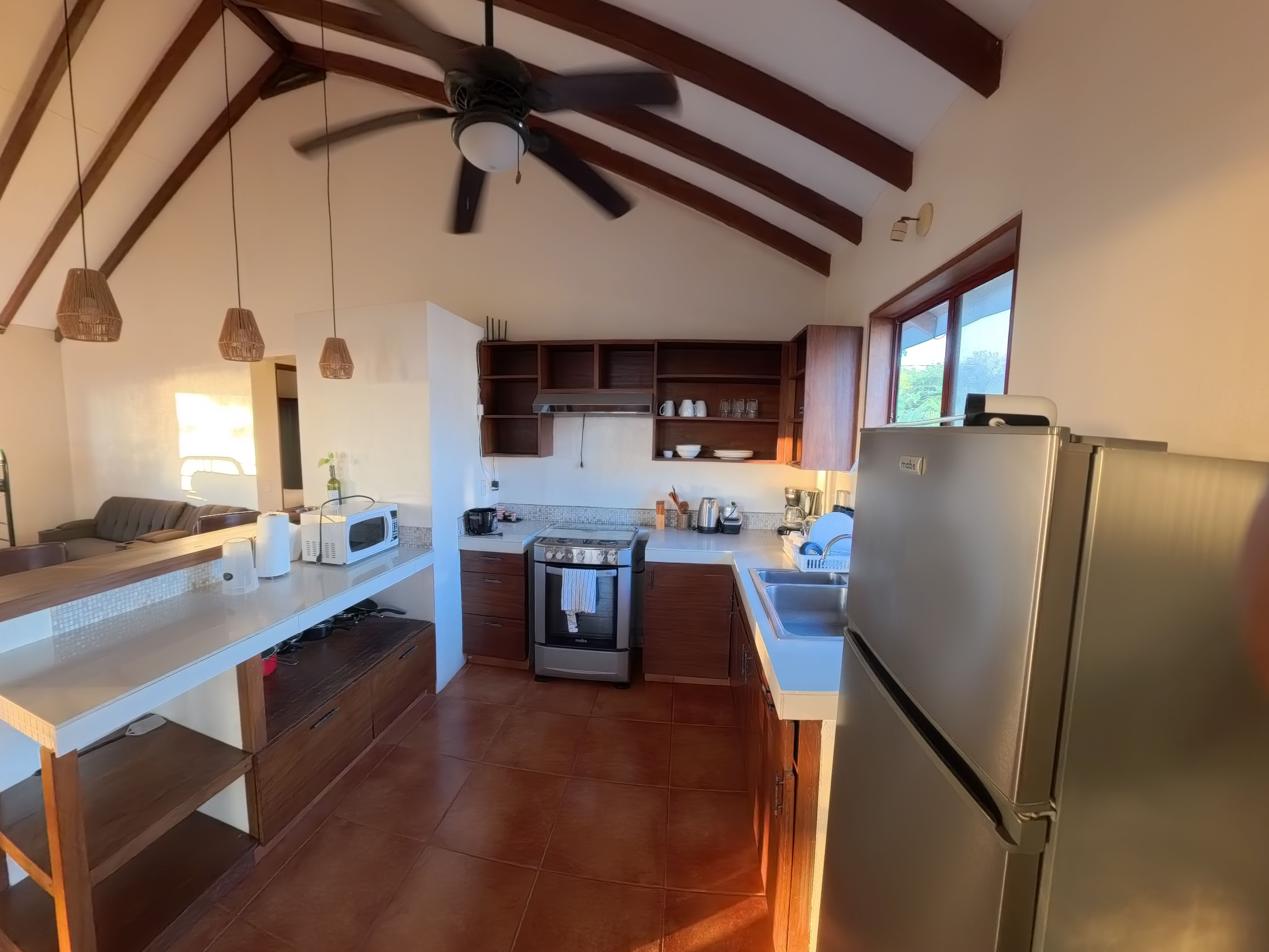 Una cocina moderna con horno empotrado, microondas y refrigerador de acero inoxidable.
