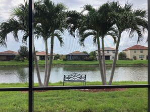 A view of a water body with palm trees and a bench in the foreground, and houses in the background. - Immaculate and Stylish Villa in the Gated Community of Gran Paradiso (Venice)