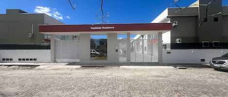 A building with a sign reading 'Capitania Residence' and a gated entrance.