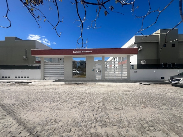 A building with a sign reading 'Capitania Residence' and a gated entrance. - Capitania Residence (Porto Seguro)