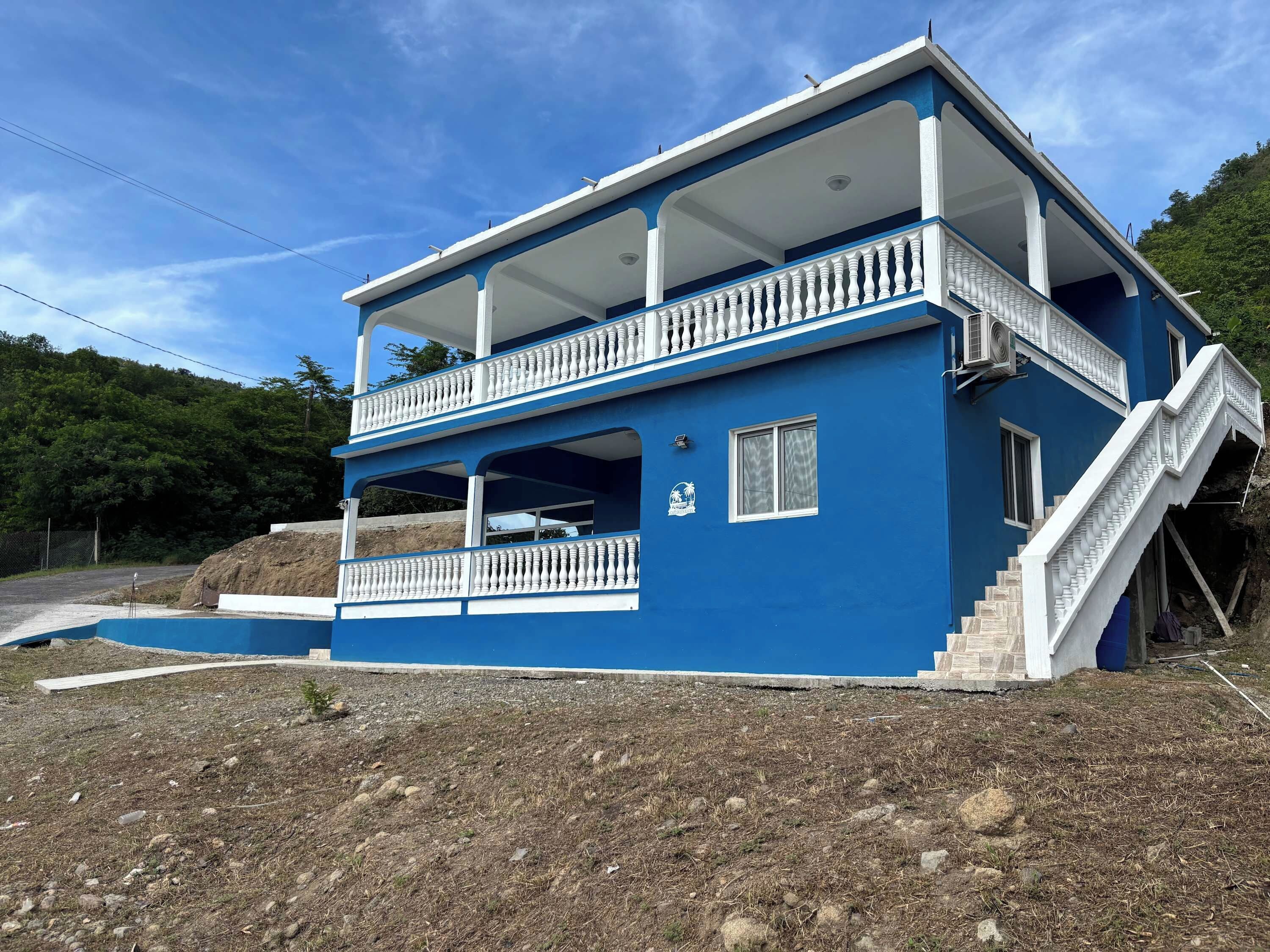 Un bâtiment à deux étages doté d’un balcon et d’un escalier.