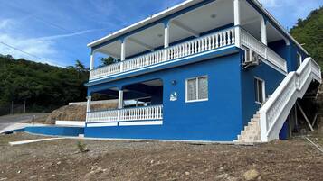 Un bâtiment à deux étages doté d’un balcon et d’un escalier.