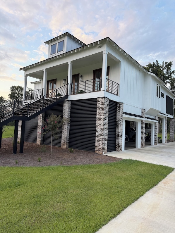 A two-story house with a covered garage, a balcony, and a staircase leading to the upper floor.