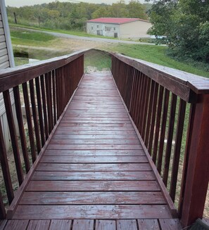 A wooden deck leading to a house with a red roof. - Newly renovated 3-bedroom mobile home in beautiful Louisa. (Louisa)