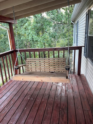 A wooden deck with a bench and a swing. - Newly renovated 3-bedroom mobile home in beautiful Louisa. (Louisa)