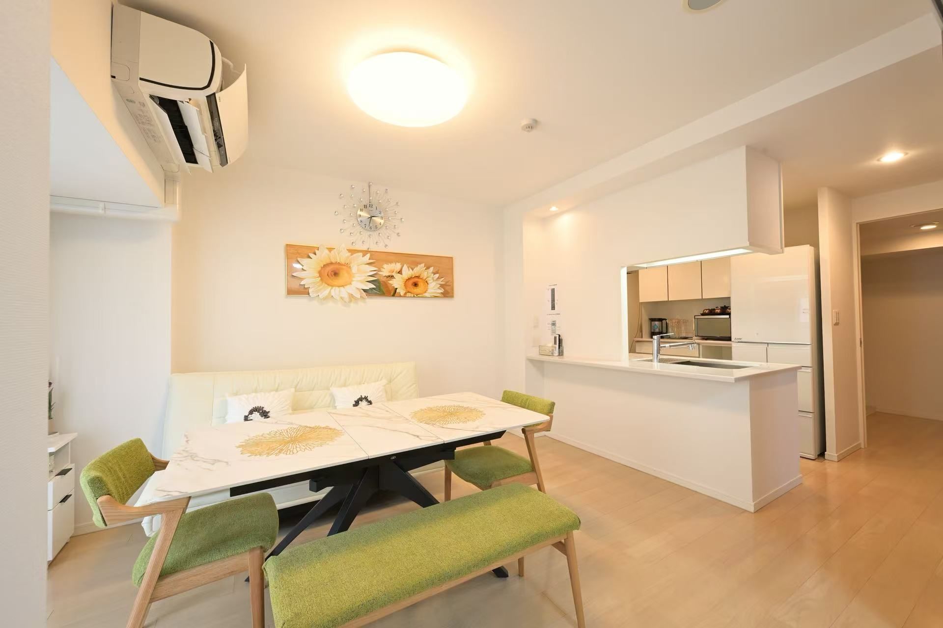 A modern kitchen with white cabinets, a built-in oven, and a refrigerator.