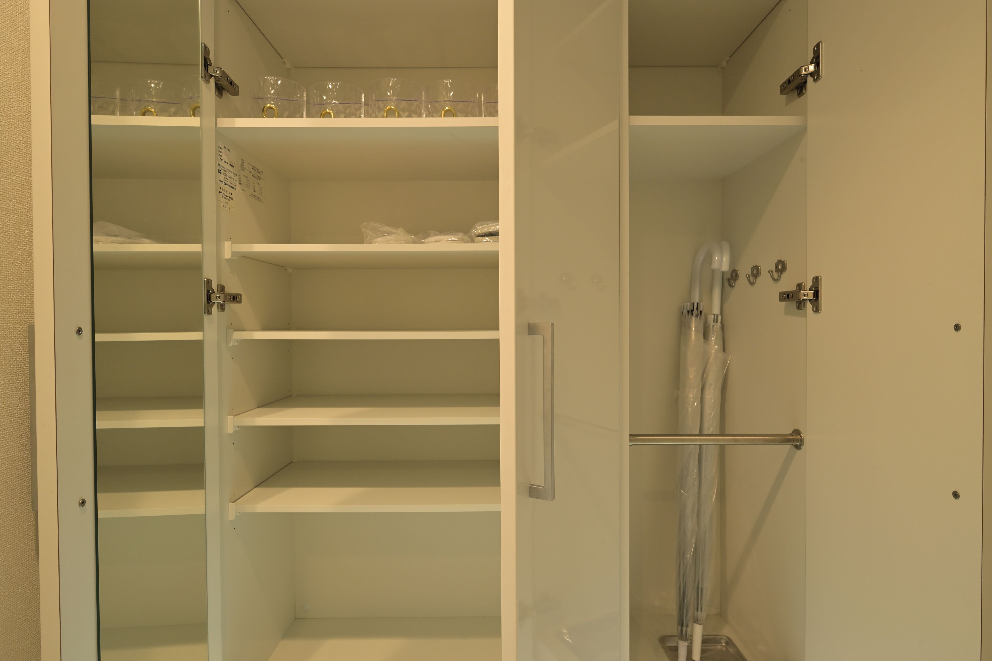 A walk-in closet with open shelves and a shower area.