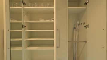 A walk-in closet with open shelves and a shower area.
