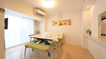 A dining area with a table, chairs, and a wall-mounted clock.