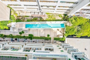 Ein Poolbereich auf dem Dach mit mehreren Terrassenebenen und einem zentralen Schwimmbecken.