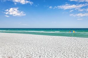 Une plage de sable blanc, sous un ciel bleu azur.