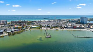 An aerial view of a coastal resort area with a marina, beachfront, and various buildings including hotels and restaurants. - Sabine Yacht & Racquet Club 6C | Spectacular Pensacola Beachfront Views | Beach Svc (Pensacola Beach)