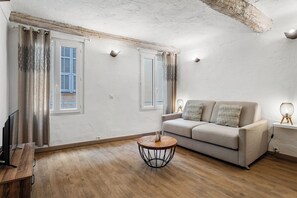 Ein modernes Wohnzimmer mit einer Couch, einem Couchtisch und einem Fernseher.