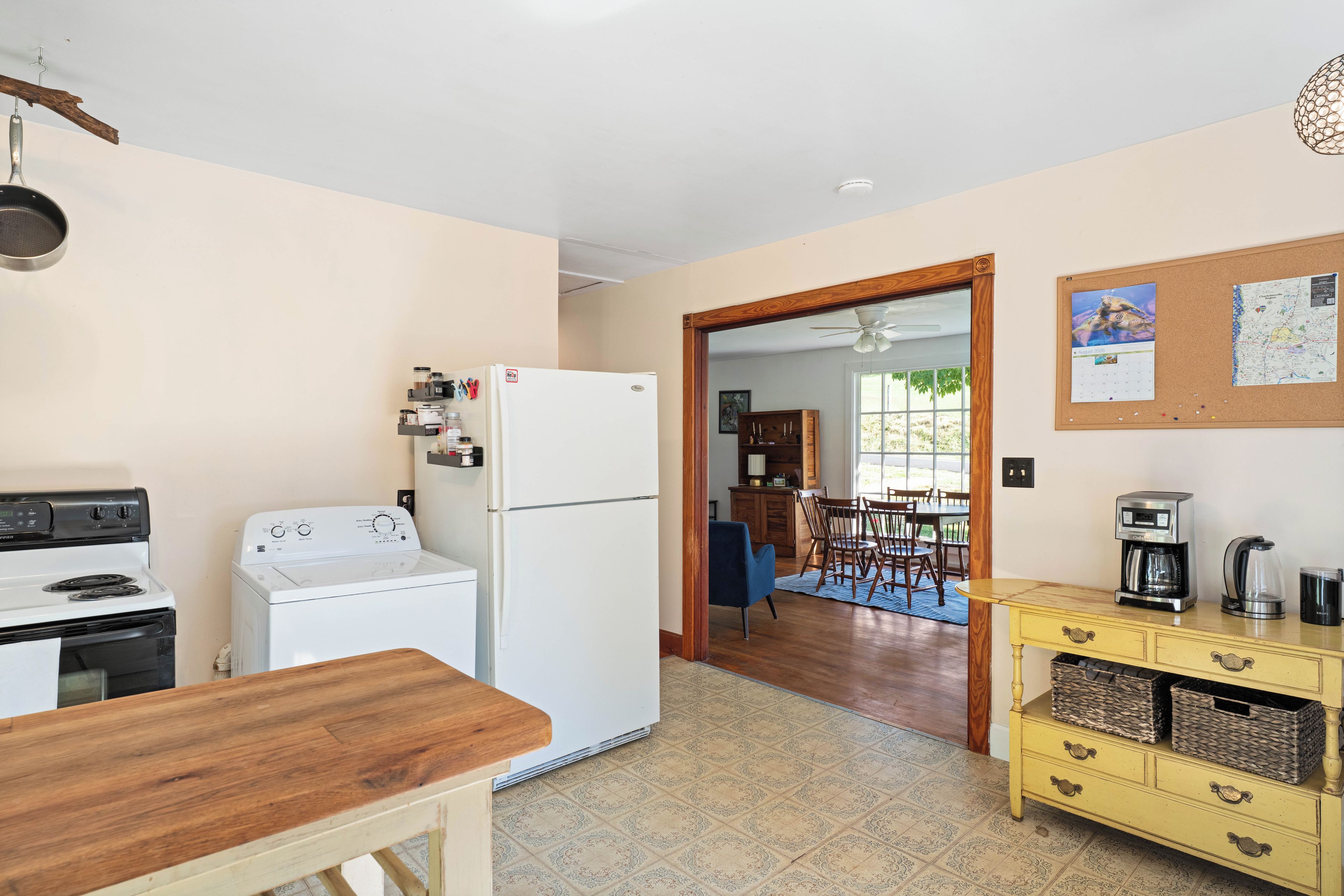A compact kitchen with a stove, refrigerator, and a dining area with a table and chairs.