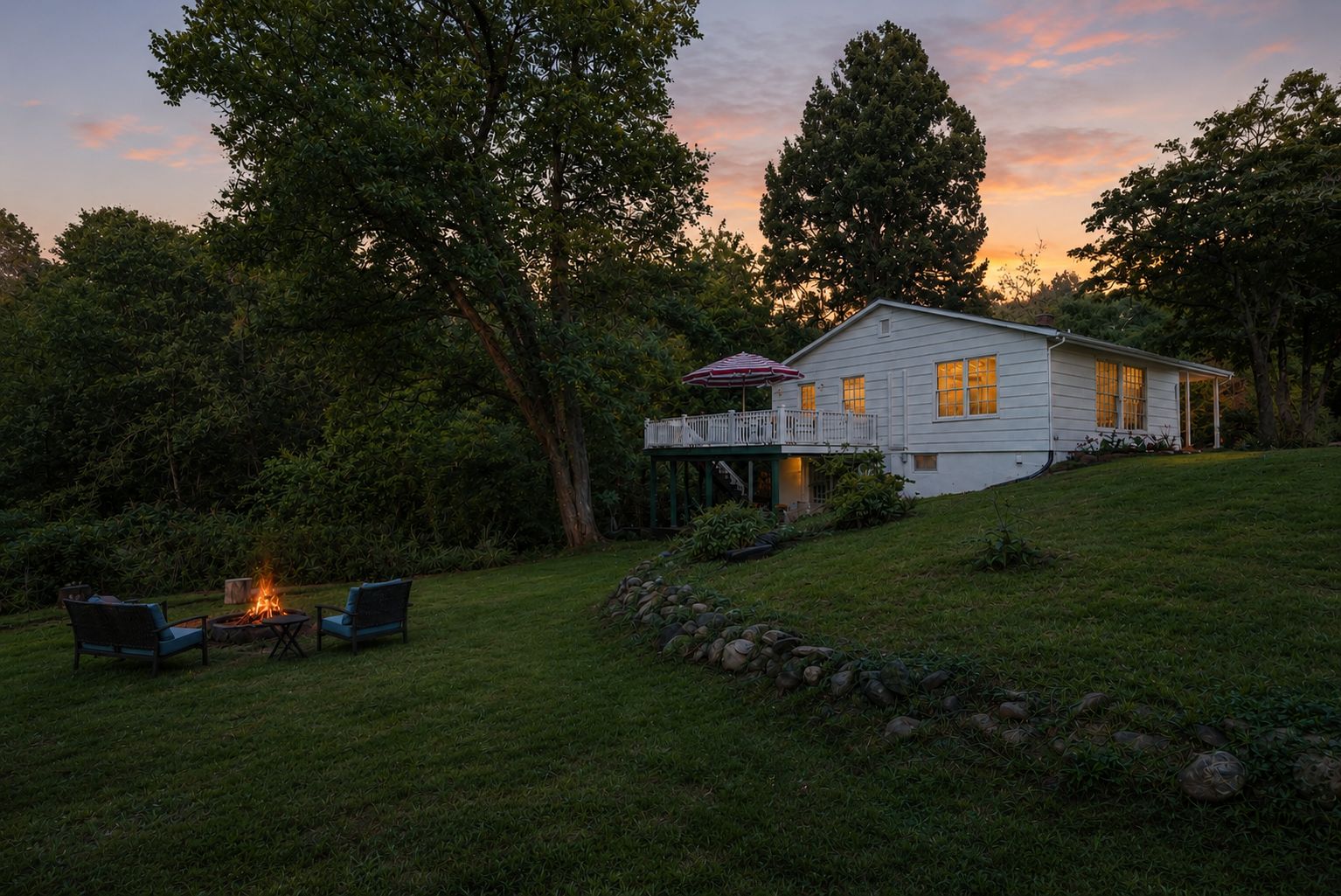 A house with a deck, a fire pit, and outdoor seating.