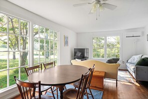 A spacious room with a dining table, chairs, a sofa, and a television. - Cozy Cottage Near Charlottesville & Wine Country (Charlottesville)