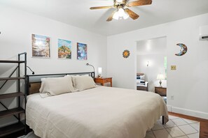 A bedroom with a bed, a desk, a chair, a ladder, and a ceiling fan. - Cozy Cottage Near Charlottesville & Wine Country (Charlottesville)