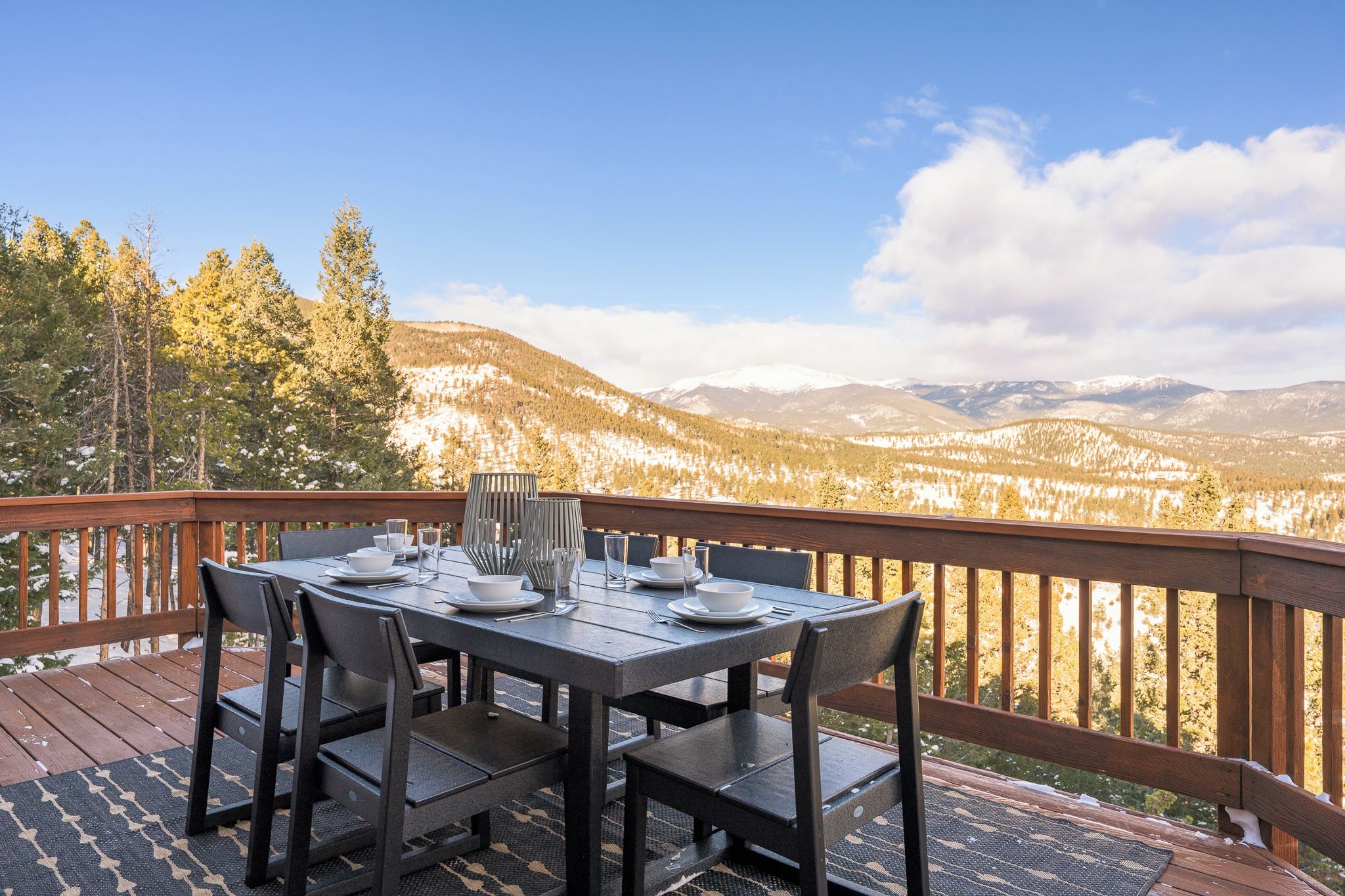 Mesa de comedor al aire libre con vistas a montañas y árboles.