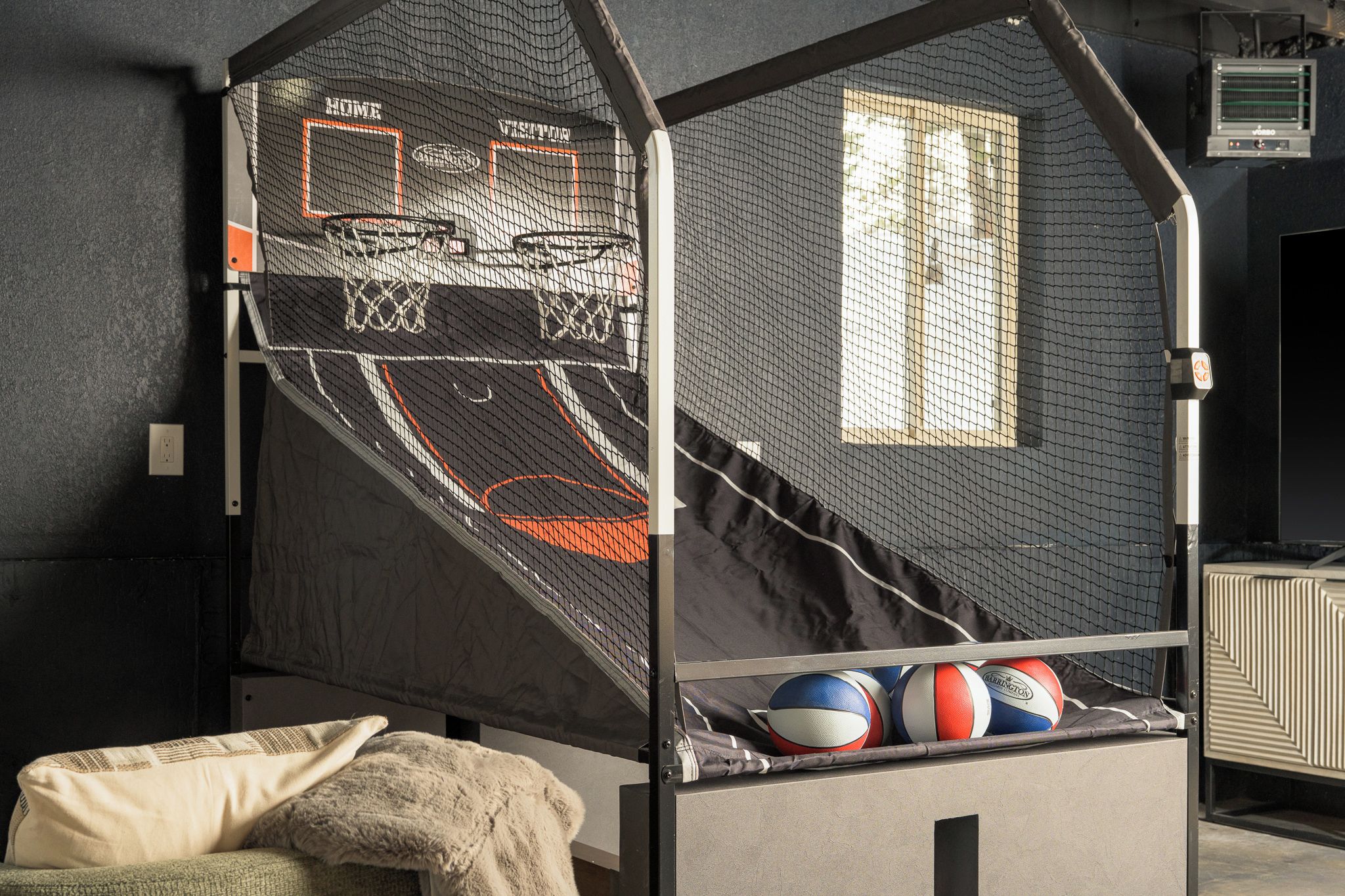 En våningssäng med en basketkorg med nät och ett fönster.