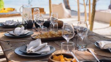 Una mesa de madera con platos, cuencos y vasos, que sugiere una disposición para comer.