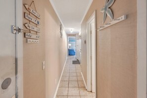 A hallway with directional signs, a door with a handle, and a ceiling light. - Windy Hill Oceanfront Suite, Pool & Hot Tub (North Myrtle Beach)
