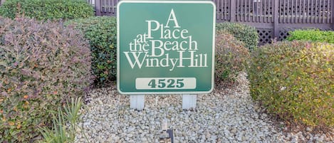 Un cartel que indica 'A Place at the Beach Windy Hill' con la dirección 4525.