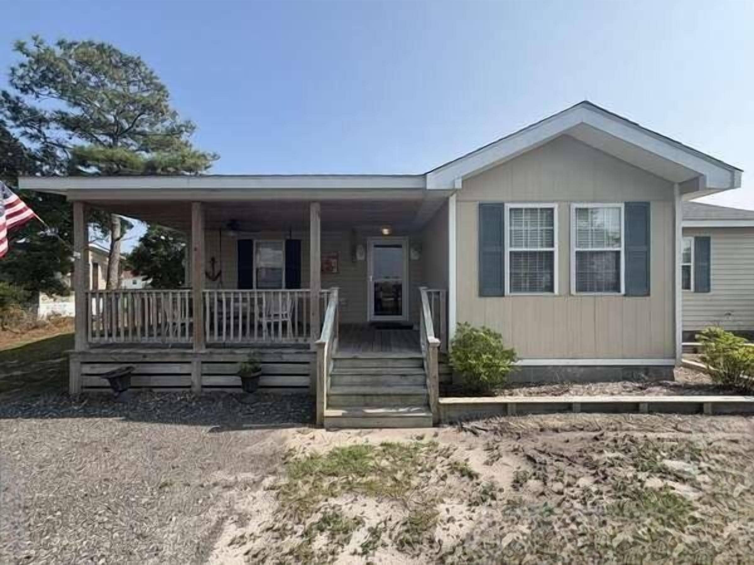 A single-story house with a front porch, a front door, and a small front yard.