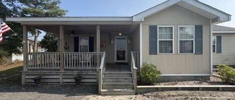 A single-story house with a front porch, a front door, and a small front yard.