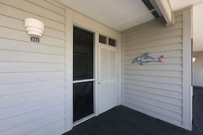 A building entrance with a closed door, a mailbox, and a sign with a dolphin and the text 'The Bunns' on the wall. - Pack the Flip‑Flops — Family Fun Starts Here (Atlantic Beach)