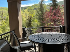 A balcony with a round table and chairs, overlooking a mountainous landscape with trees. - Beaver Creek Slopeside - True ski in/ ski out  3-bedroom condo (Beaver Creek)