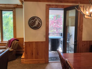 A dining area with a wooden table and chairs, a fireplace, and a view of the outdoors. - Beaver Creek Slopeside - True ski in/ ski out  3-bedroom condo (Beaver Creek)