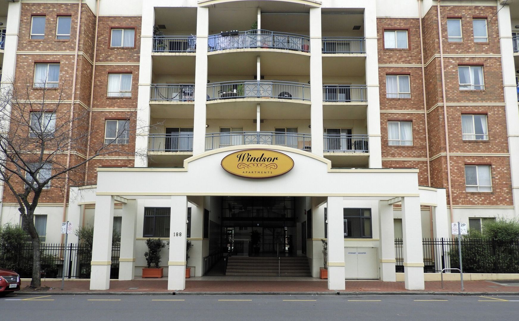 A multi-story building with a sign reading 'Windsor Apartments.'
