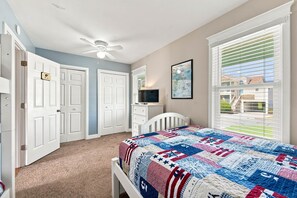 A bedroom with a bed, a ceiling fan, a television, and a window with blinds. - Beach Bungalow: Soundside, Hot Tub, Sound Views, Village Beach Club Access (Nags Head)