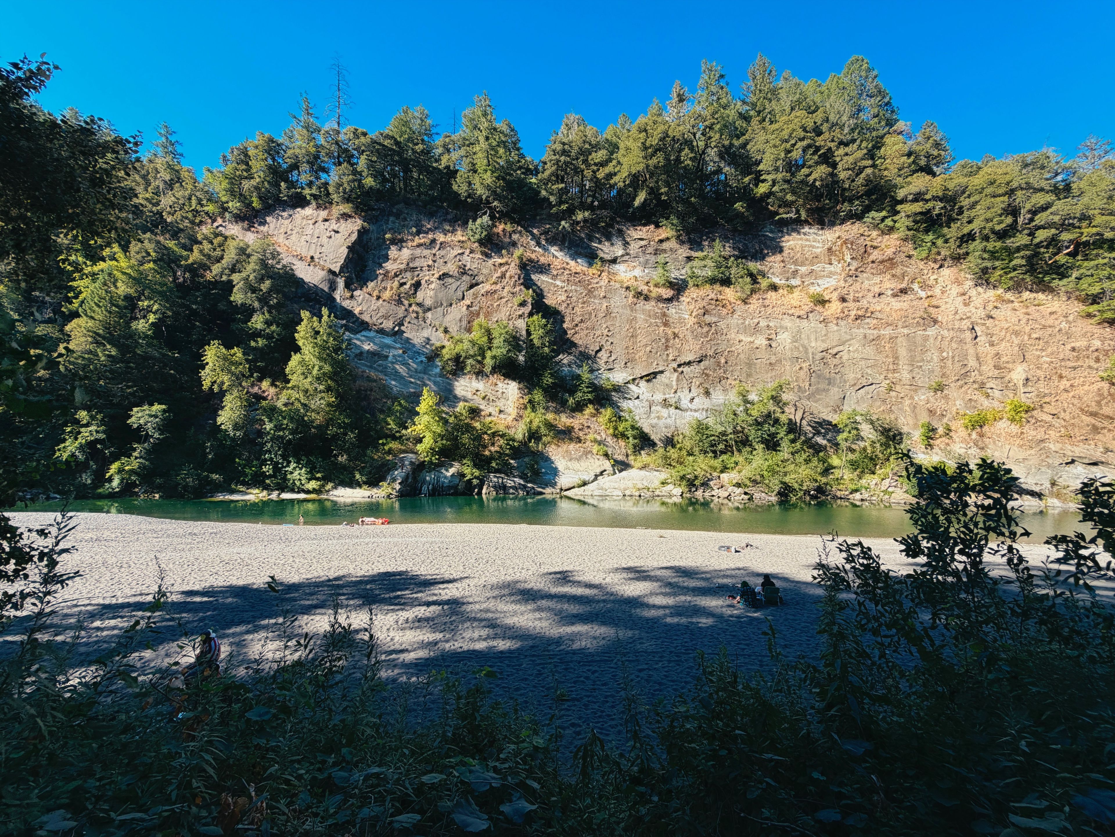 A natural landscape with a river, rocky terrain, and dense forest.