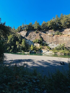 A natural landscape with a river, rocky terrain, and dense forest.
