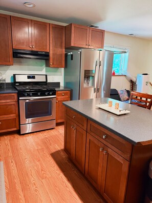 A kitchen with wooden cabinets, stainless steel appliances, and a granite countertop.