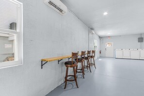 A conference room with a long table and four chairs, white walls, and a door with an exit sign. - Poolside Fun, Pickleball & Coastal Adventures Await in Fort Myers - Jefferson Palms I - Roelens (Fort Myers Beach)