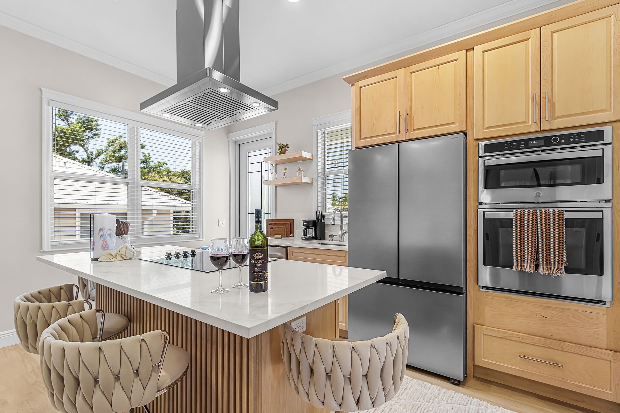 A modern kitchen with a central island, stainless steel appliances, and wooden cabinetry.