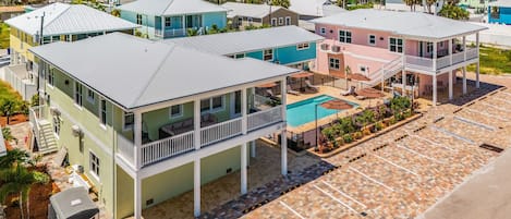 A coastal residential area with multiple two-story houses featuring balconies, a swimming pool, and a parking lot.