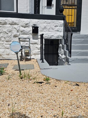 A residential area with a gated entrance, a mailbox, and a stop sign.