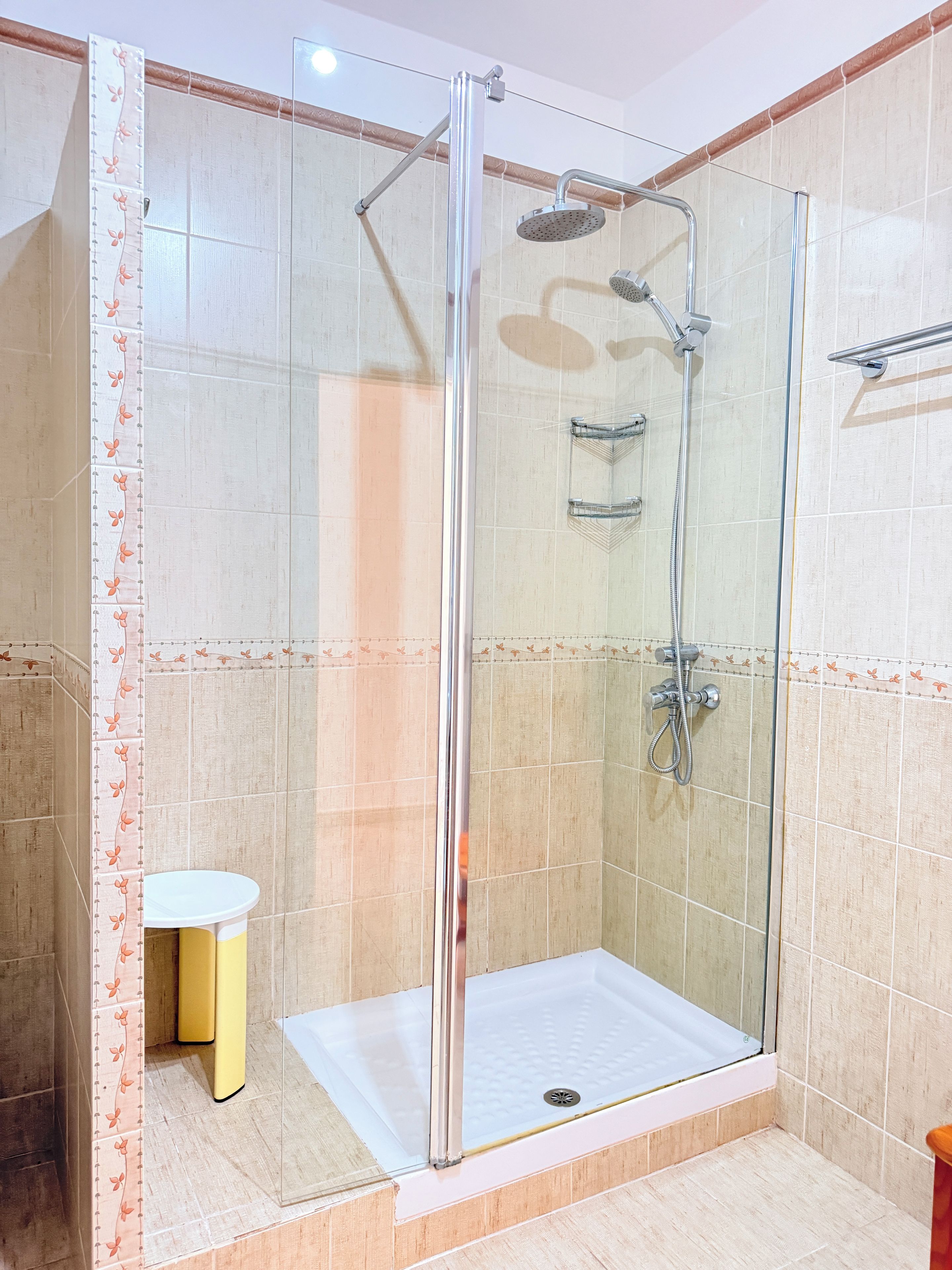 Cabina de ducha con paredes de vidrio, ducha de mano y ducha de mano.