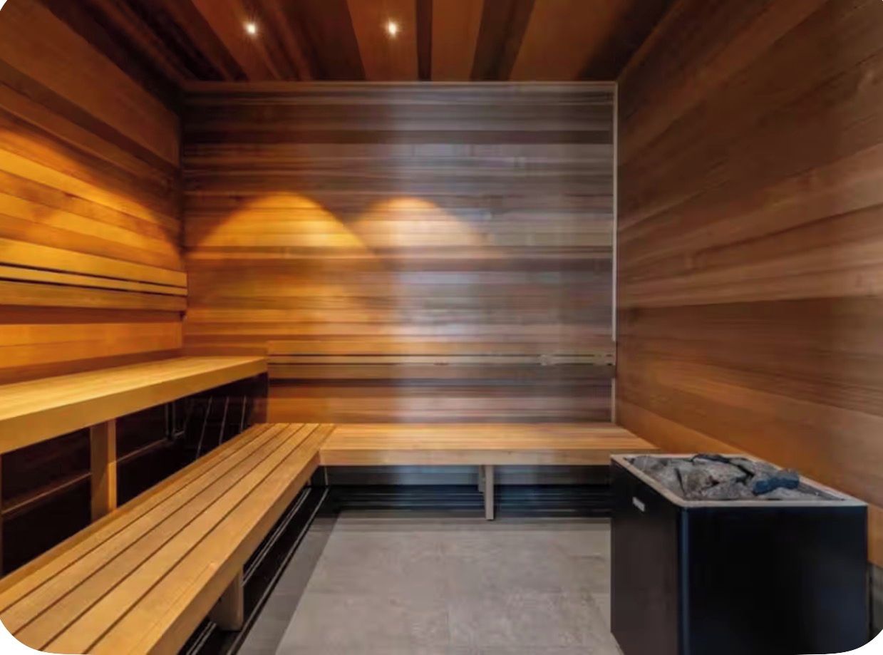 A sauna with wooden benches and a charcoal stove.