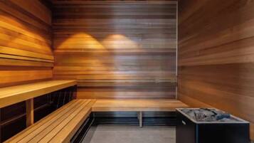 A sauna with wooden benches and a charcoal stove.