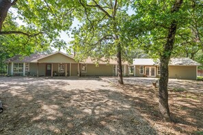 A row of single-story houses with a gravel driveway and trees in the foreground. - White Oak Retreat! 17 mins to Silos! (Waco)