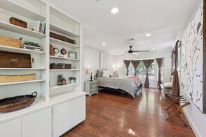 A bedroom with a large bed, a nightstand, a dresser, and a bookshelf. - White Oak Retreat! 17 mins to Silos! (Waco)