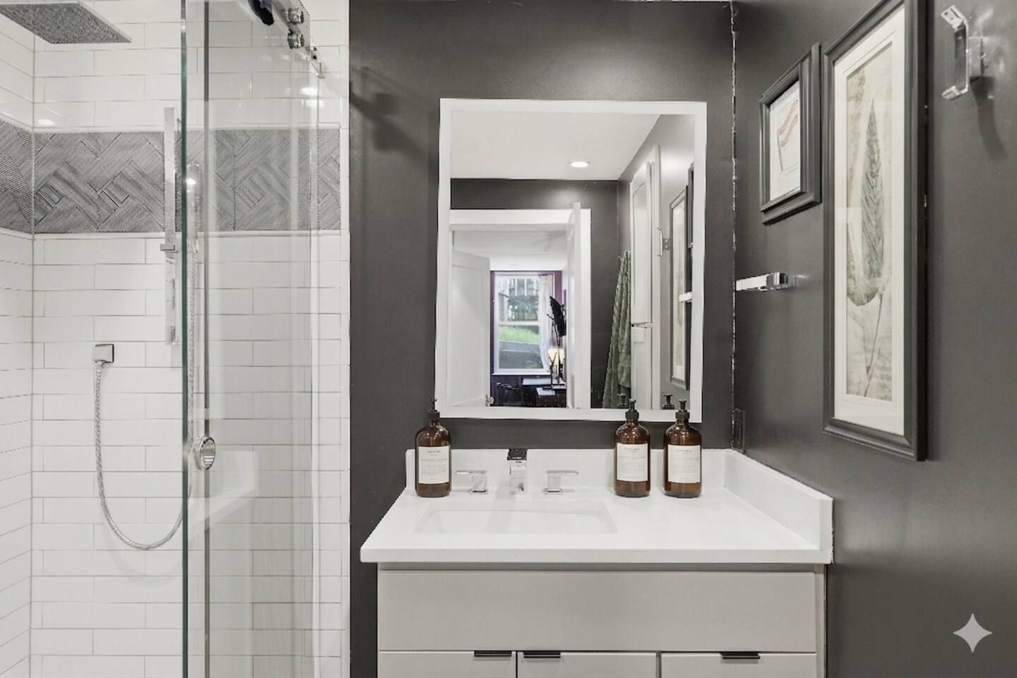 A modern bathroom with a glass shower enclosure, a white vanity with two sinks, and a large mirror.